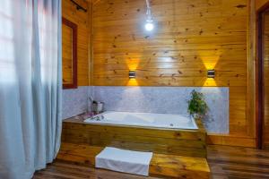 y baño con bañera en una pared de madera. en Fazenda Rincão Comprido Urubici, en Urubici