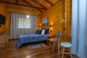 1 dormitorio con 1 cama, mesa y sillas en Fazenda Rincão Comprido Urubici, en Urubici