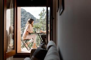 a woman sitting at a table on a balcony at Apartamento Al Alba in Albarracín