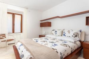 1 dormitorio blanco con 1 cama y 1 silla en Nice and spacious apartment in the heart of gallura, en Tempio Pausania