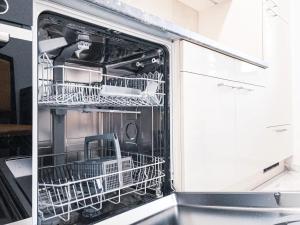 an open dishwasher with dishes inside of it at 268 Leipzig Plagwitz Apartment Kulturviertel in Leipzig