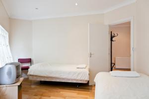 a bedroom with two beds and a tv in it at Apartments close Spurs stadion station 1 minute away in London