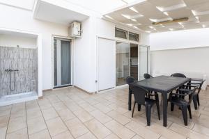 une salle à manger avec une table et des chaises noires dans l'établissement Appartamento climatizzato a 50 m dal mare nel centro di Torre San Giovanni, à Torre San Giovanni