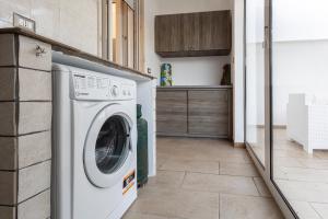 - une buanderie avec un lave-linge et un sèche-linge dans l'établissement Appartamento climatizzato a 50 m dal mare nel centro di Torre San Giovanni, à Torre San Giovanni 6 autres photos