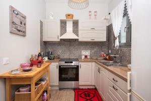 a kitchen with white cabinets and a stove top oven at Stellas guesthouse near Arachova in Stírion