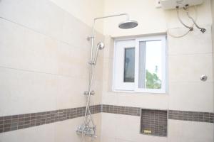 y baño con ducha y ventana. en Green Court Serviced Apartments, en Accra