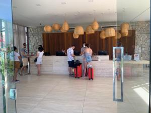 um grupo de pessoas em pé em um lobby com bagagem em Ilê de Pipa Blz em Pipa mais 50 fotografias