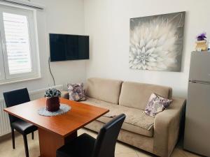 uma sala de estar com um sofá e uma mesa em Guest House Ruža em Sobra