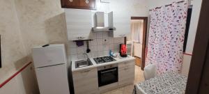 a small kitchen with a refrigerator and a sink at casa epomeo in Catania