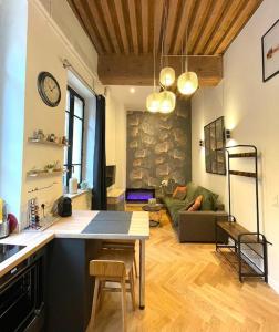 een keuken en een woonkamer met een tafel en een bank bij Logement de charme avec balnéo in Lyon