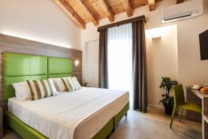 a bedroom with a large bed with a green headboard at Brussa Horse Oasi in Caorle