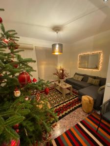 a living room with a christmas tree and a couch at Ortansia in Dimitsana