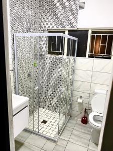 La salle de bains est pourvue d'une douche et de toilettes. dans l'établissement La Maison, à Lichtenburg