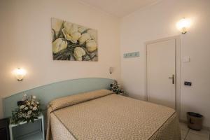 a bedroom with a bed and a painting on the wall at Hotel Riviera Blu in Tirrenia