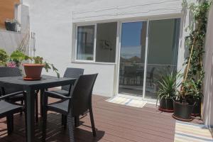 un patio con mesa y sillas en una terraza en Ático Moderno - Out of Blue, en Santa Cruz de la Palma