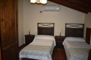 2 łóżka pojedyncze w pokoju z 2 lampami w obiekcie Hotel Rural El Refugio de Los Templarios w mieście Cabeza del Buey