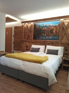 a bedroom with a large bed with a painting on the wall at Affittacamere Villa Sole in Fiera di Primiero