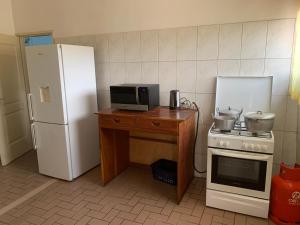 a kitchen with a refrigerator and a table with a microwave at Luxious Cosy Apart 2 Bedroom Cotonou Centre in Cotonou
