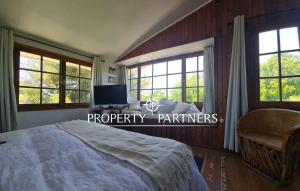 a bedroom with a bed and a tv and windows at Casas Pamelas in Algarrobo