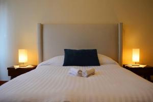 a bed with two towels on it with two lamps at Beautiful home w/Pool @Capilla de Piedra in San Miguel de Allende +7 photos