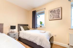a bedroom with two beds and a window at MODERN HOUSE near the CITY CENTRE in Peterborough