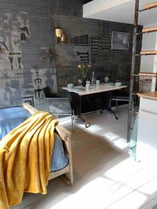una habitación con una mesa y una manta amarilla en una cama en Mooi appartement in Werkplaats, en Kampen