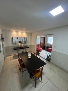 a dining room with a black table and chairs at Hangar House in Belém