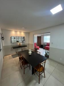 uma sala de jantar com uma mesa preta e cadeiras em Hangar House em Belém