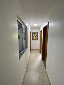 a hallway with white walls and a tile floor at Hangar House in Belém