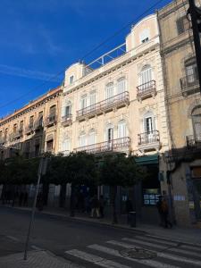 a large white building with balconies on a city street at ATICO SUITE CLAUDIO MARCELO in Córdoba