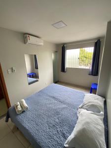 a bedroom with a blue bed and a window at Hangar House in Belém
