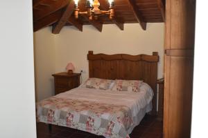 1 dormitorio con cama y lámpara de araña en Hotel Rural El Refugio de Los Templarios, en Cabeza del Buey
