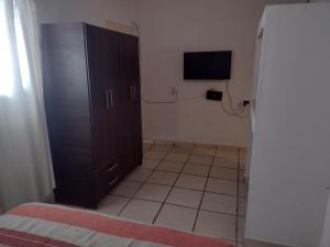 Habitación con armario negro y TV. en Departamentos Tierra Colorada en La Rioja