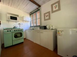 a kitchen with a green stove and a refrigerator at Uva Dulce in Tunca Arriba