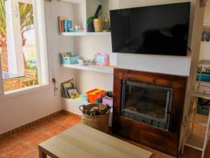 sala de estar con chimenea y TV de pantalla plana en Three bedroom house by the sea, en Agua Amarga
