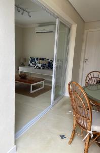 Habitación con una puerta de cristal que conduce a un dormitorio. en Villa Dei Fiori en São Sebastião