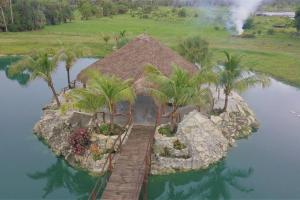 an island in the water with palm trees and a house at Beautiful Vacation Home Across From Lake Okeechobee in Okeechobee