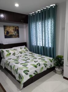 1 dormitorio con cama y cortina azul en Simply Comfy 916 (Cityscape Bacolod), en Bacolod
