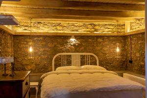 a bedroom with a bed and a stone wall at Managraia in Makrýgialos