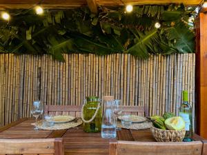 a wooden table with plates of food and wine glasses at Azores Bagus Surf House in Ponta Delgada