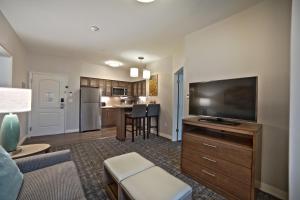 a living room with a flat screen tv and a kitchen at Staybridge Suites Houston - Humble Beltway 8 E, an IHG Hotel in Humble