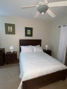 a bedroom with a bed with a ceiling fan at Club Caribbean Apartments in Runaway Bay