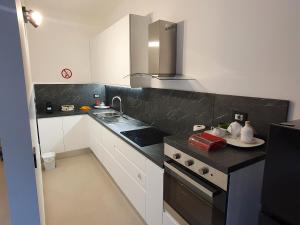 a kitchen with white cabinets and a black counter top at Il Giardino dei Sorrisi in Ostuni