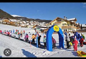 a group of people standing around a blue arch in the snow at Gasthof Hohenbichl in Terento