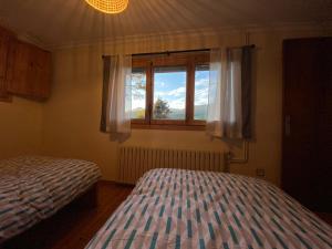 1 dormitorio con 2 camas y ventana en Els Marges, en Sant Joan de les Abadesses