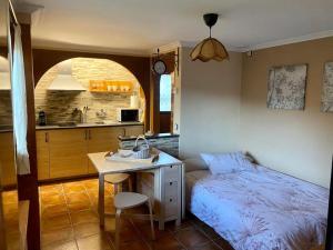 ein Schlafzimmer mit Bett und Schreibtisch sowie eine Küche in der Unterkunft Els Marges in Sant Joan de les Abadesses