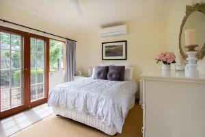 1 dormitorio con cama y espejo en Riverlea Cottage en Apple Tree Flat