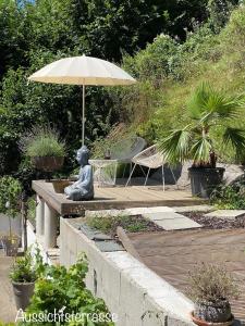 una estatua de una mujer sentada bajo un paraguas en Happy Amadei en Sankt Veit im Pongau