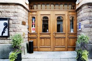 una grande porta in legno di un edificio con due piante di Hotel Hellsten a Stoccolma