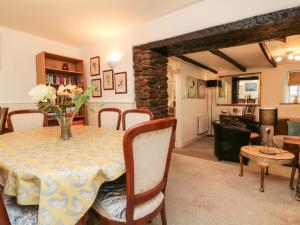 a dining room with a table and a living room at Tythe Barn House in Ilfracombe